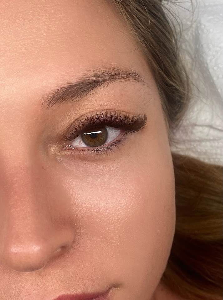 Wet-look lash set close-up on a green-eyed client