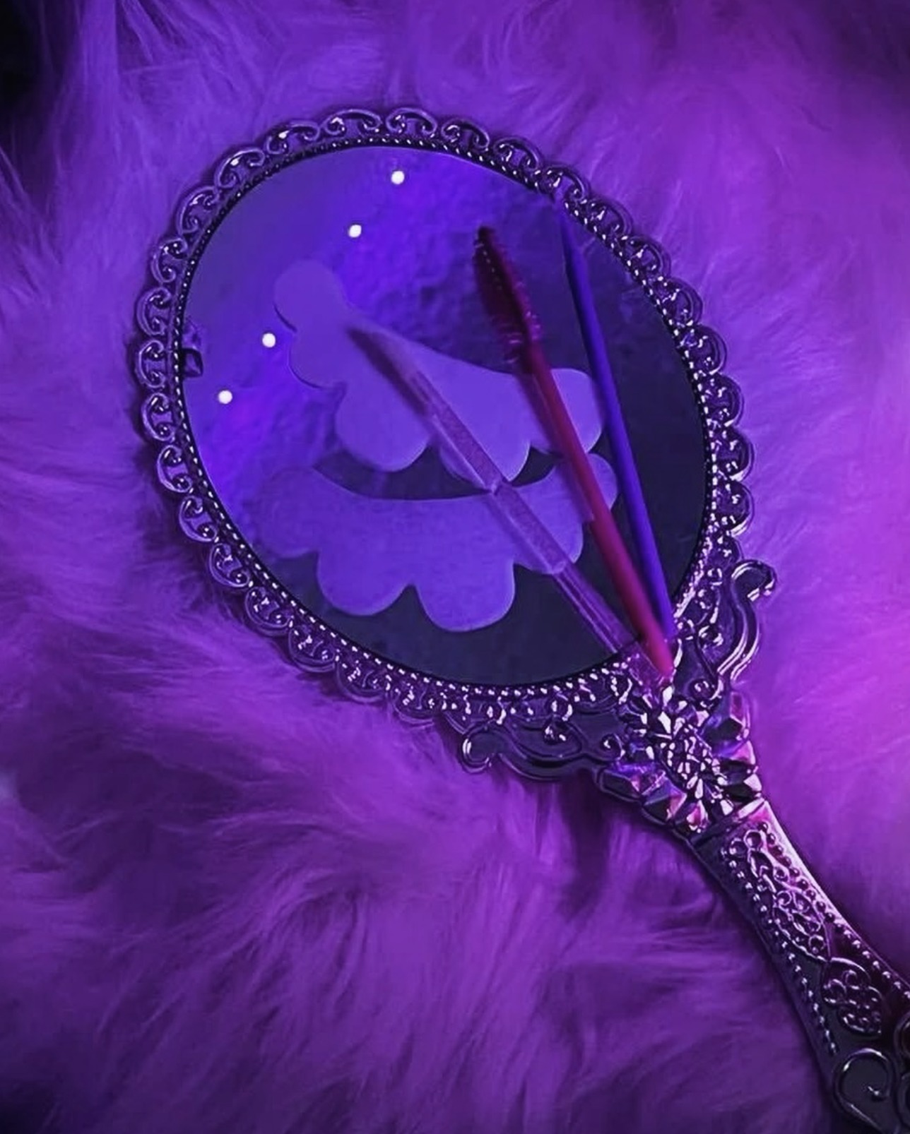 Ornate purple hand mirror styled with lash tools in the Lashes by Dee studio