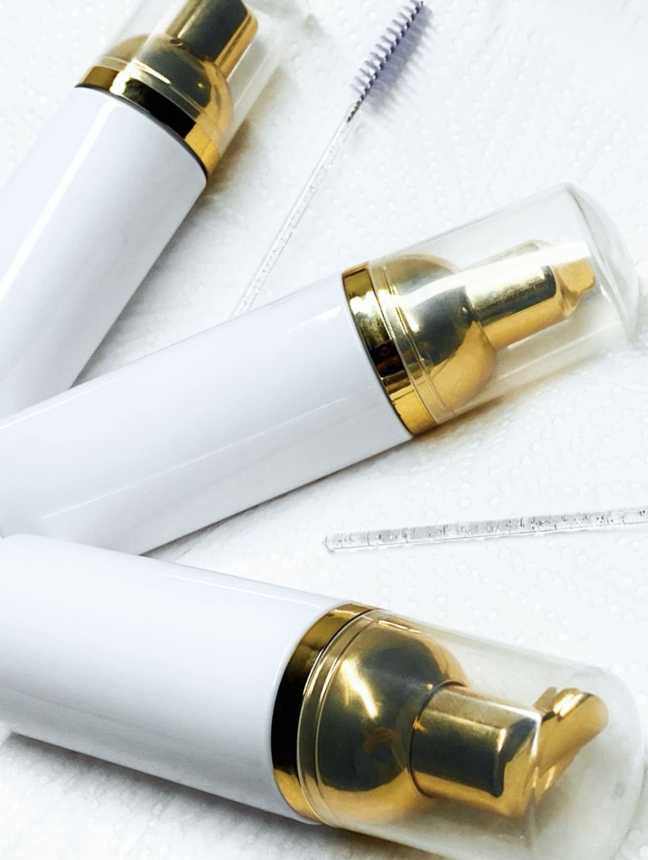 White and gold lash cleanser bottles for daily aftercare — Lashes by Dee